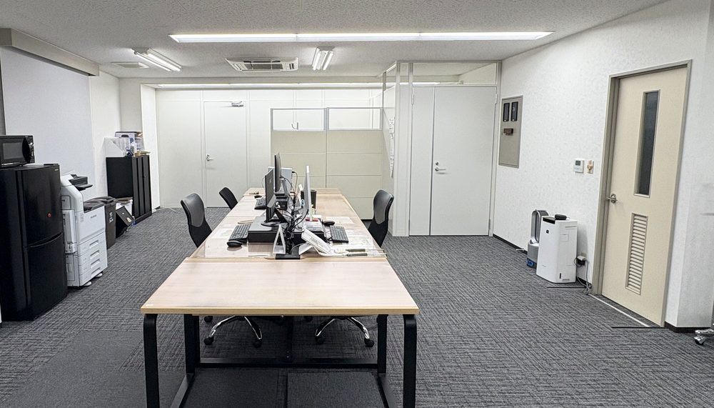ONS株式会社の執務フロア。デスクと複合機を備えた作業スペース